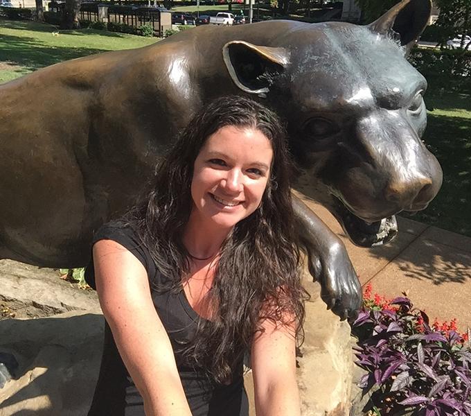 Alison Anne Zappa sitting on the bronze panther statue