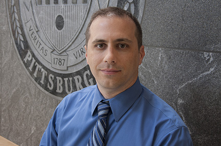 Phil Empey in front of University Seal